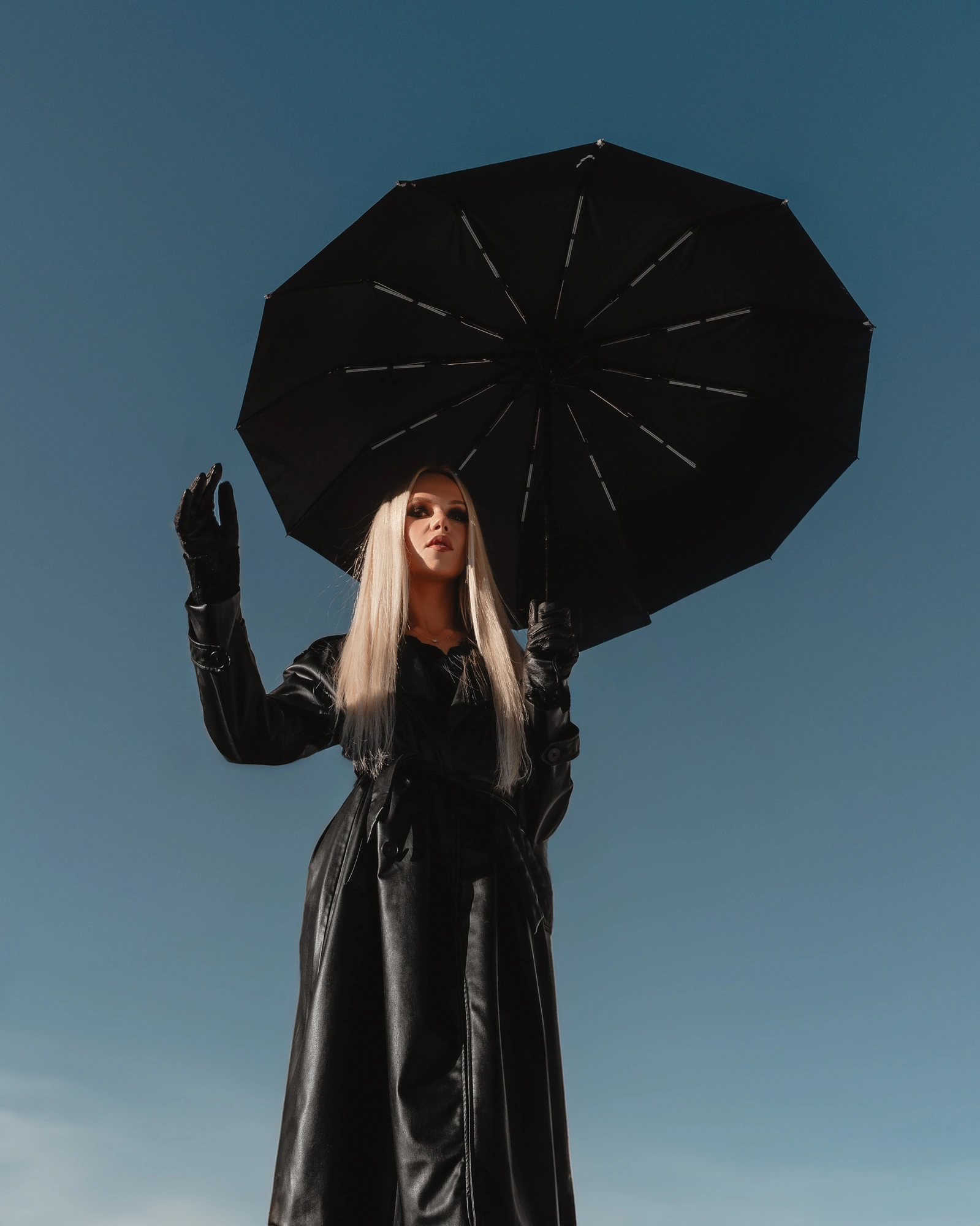 Model portrait with black umbrella against blue sky as fashion and editorial photography for creators, models and personal brands by Šime Bilić.